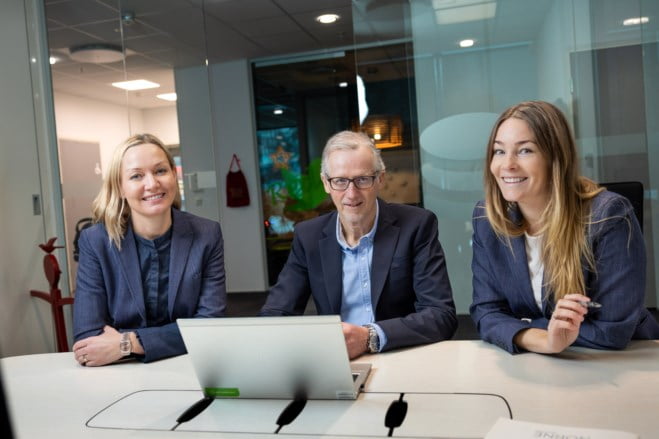 BM-rådgiverne Kristine, Terje og Bjørg Torhild smiler rundt en PC